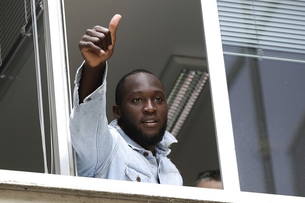 Soccer forward Romelu Lukaku gives his thumbs up as he salutes Inter Milan supporters from a window of the Italian Olympic Committee's headquarters, in Milan,Italy, Thursday, Aug. 8, 2019. Manchester United forward Lukaku is on the verge of completing his move to Inter Milan on the final day of transfers in England. (AP Photo/Luca Bruno)