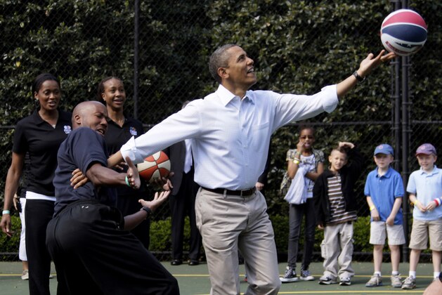 FILE - In this April 9, 2012, file photo, President Barack Obama plays basketball with former NBA basketball player Bruce Bowen during the annual White House Easter Egg Roll at the White House in Washington. Bidding was drawing to a close Friday, Aug. 16, 2019, for a basketball No. 23 Punahou School jersey believed to have been worn by President Barack Obama. Obama the wore that number during the 1978-79 school year in Honolulu. (AP Photo/Carolyn Kaster, File)