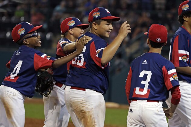 Elizabeth, New Jersey's Derek Escobar, center, celebrates with teammates after getting the final out of a 2-0 win over Barrington, Rhode Island in an elimination baseball game at the Little League World Series tournament in South Williamsport, Pa., Tuesday, Aug. 20, 2019. (AP Photo/Gene J. Puskar)