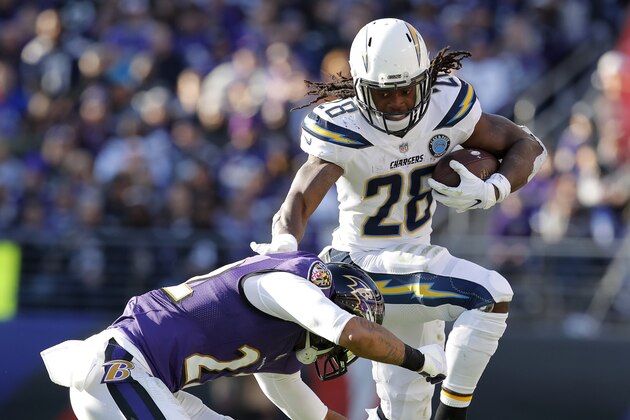Los Angeles Chargers running back Melvin Gordon (28) leaps to avoid Baltimore Ravens cornerback Jimmy Smith (22) in the first half of an NFL wild card playoff football game, Sunday, Jan. 6, 2019, in Baltimore. (AP Photo/Carolyn Kaster)