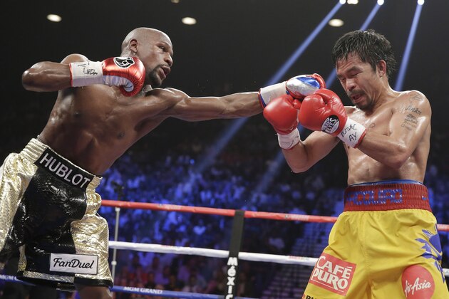 Floyd Mayweather Jr., left, stops Manny Pacquiao, from the Philippines, with a left during their welterweight title fight on Saturday, May 2, 2015 in Las Vegas. (AP Photo/Isaac Brekken)