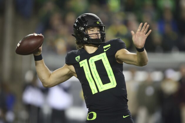 File-This Nov. 17, 2018, file photo shows Oregon quarterback Justin Herbert throwing down field against Arizona State during the first quarter of an NCAA college football game in Eugene, Ore.  Herbert says he’ll return for his senior season. Herbert announced his decision on Wednesday, Dec. 26, 2018, before the Oregon left Eugene for the Redbox Bowl. Oregon plays Michigan State on Monday. (AP Photo/Chris Pietsch, File)