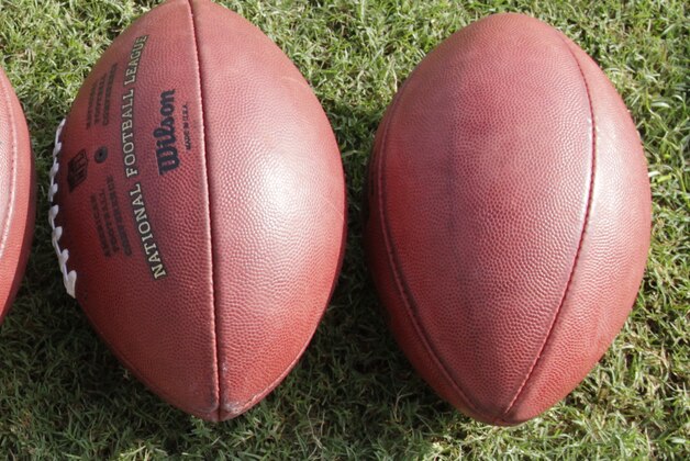 Footballs lie on the ground at the New Orleans Saints NFL football training camp in Metairie, La., Friday, Aug. 6, 2010.  (AP Photo/Bill Haber)