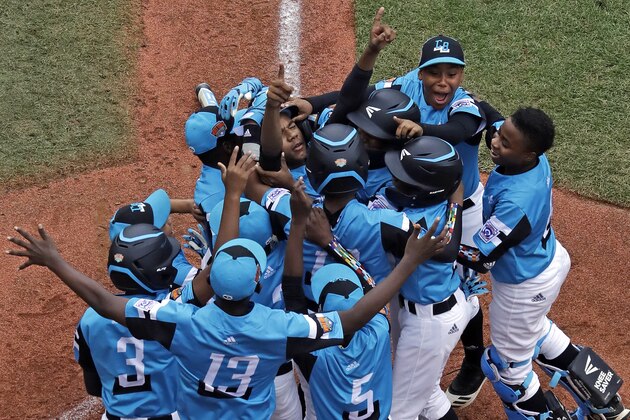 Curacao's Clay Winklaar (looking up), center, celebrates as he crosses home plate and is greeted by teammates after hitting a grand slam off South Korea's Jinwon Na, left, during the first inning of an elimination baseball game at the Little League World Series tournament in South Williamsport, Pa., Thursday, Aug. 22, 2019. (AP Photo/Gene J. Puskar)