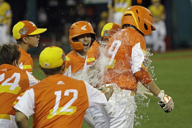 River Ridge, La.'s Conner Perrot (9) gets doused with water by teammates Egan Prather, left, and Jeffrey Curtis (12) after he drove in the final run in the team's 10-0 win against South Riding, Va., during the fifth inning of a baseball game at the Little League World Series in South Williamsport, Pa., Thursday, Aug. 22, 2019. Louisiana won 10-0. (AP Photo/Tom E. Puskar)