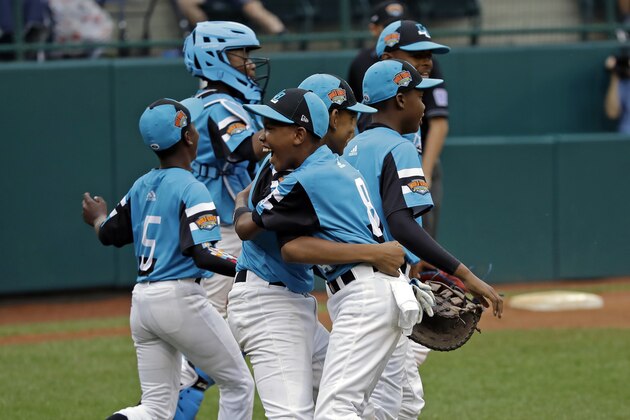 Curacao's Clay Winklaar, right and Farens Wooter embrace as they celebrate a 5-3 win against South Korea during a baseball game at the Little League World Series tournament in South Williamsport, Pa., Thursday, Aug. 22, 2019. (AP Photo/Tom E. Puskar)