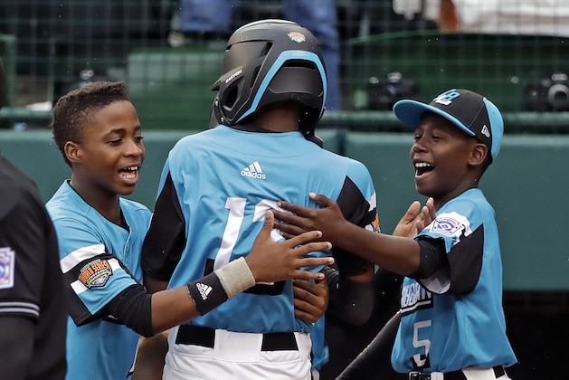 Curacao's Curley Martha, center, is greeted by Shendrion Martinus, left, and Fran-J Confesor after hitting a solo home run off South Korea's Jinwon Na (13) during the third inning of a baseball game at the Little League World Series in South Williamsport, Pa., Thursday, Aug. 22, 2019. Curacao won 5-3. (AP Photo/Gene J. Puskar)