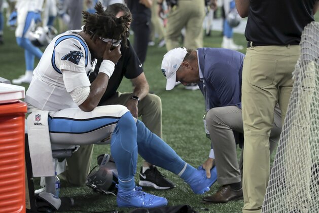 Carolina Panthers quarterback Cam Newton (1) receives attention on the sideline after an injury in the first half of an NFL preseason football game against the New England Patriots, Thursday, Aug. 22, 2019, in Foxborough, Mass. (AP Photo/Charles Krupa)