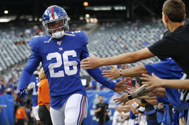FILE - In this Aug. 16, 2019, file photo, New York Giants running back Saquon Barkley (26) greets fans before an NFL football game against the Chicago Bears in East Rutherford, N.J. Barkley set team rookie records for yards rushing (1,307) receptions (91) and total touchdowns (15) playing behind a bad line. With trade acquisition Kevin Zeitler at right guard, free agent Mike Remmers at right tackle and C Jon Halapio back from from a major leg injury, this could be an even bigger year for the NFL Offensive Rookie of the Year and the league leader in yards from scrimmage (2,028). (AP Photo/Adam Hunger, File)