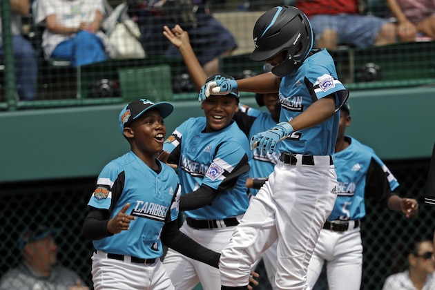 Curacao's Curley Martha (12) is greated at home plate by Deshandro Tromp and the rest of his teammates after a two run home run off of Japan's Taishi Kawaguchi in the fifth inning of the International Championship baseball game at the Little League World Series tournament in South Williamsport, Pa., Saturday, Aug. 24, 2019. (AP Photo/Tom E. Puskar)