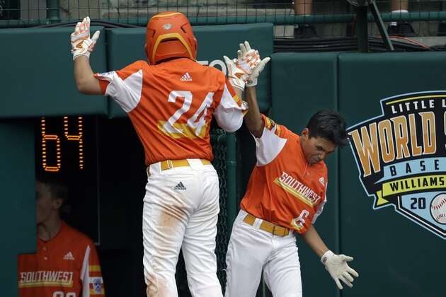 River Ridge, La.'s Egan Prather (24) celebrates scoring on a double by Ryder Planchard with Peyton Spadoni (6) on his way back to the dugout during he fifth inning against Wailuku, Hawaii, in the U.S. championship baseball game at the Little League World Series in South Williamsport, Pa., Saturday, Aug. 24, 2019. River Ridge, Louisiana won the game 9-5. (AP Photo/Tom E. Puskar)