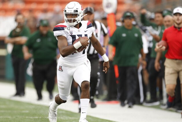 Arizona quarterback Khalil Tate (14) runs down the sideline during the second quarter during of the team's NCAA college football game against Hawaii on Saturday, Aug. 24, 2019, in Honolulu. (AP Photo/Marco Garcia)