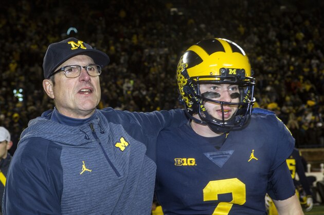 FILE - In this Nov. 17, 2018, file photo, Michigan head coach Jim Harbaugh, left, puts an arm around Michigan quarterback Shea Patterson after defeating Indiana 31-20 in an NCAA college football game, in Ann Arbor, Mich. No. 4 Michigan is in a position to win a Big Ten title for the first time since 2004 in part because the NCAA allowed Ole Miss transfer Shea Patterson to play this season for Jim Harbaugh. (AP Photo/Tony Ding, File)