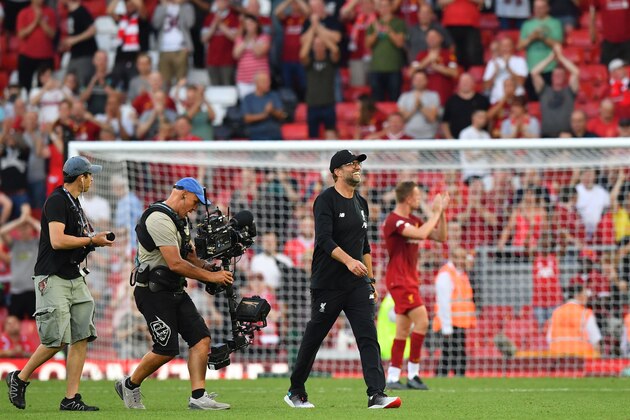 Liverpool's German manager Jurgen Klopp (C) smiles on the pitch after the English Premier League football match between Liverpool and Arsenal at Anfield in Liverpool, north west England on August 24, 2019. - Liverpool won the game 3-1. (Photo by Ben STANSALL / AFP) / RESTRICTED TO EDITORIAL USE. No use with unauthorized audio, video, data, fixture lists, club/league logos or 'live' services. Online in-match use limited to 120 images. An additional 40 images may be used in extra time. No video emulation. Social media in-match use limited to 120 images. An additional 40 images may be used in extra time. No use in betting publications, games or single club/league/player publications. /         (Photo credit should read BEN STANSALL/AFP/Getty Images)