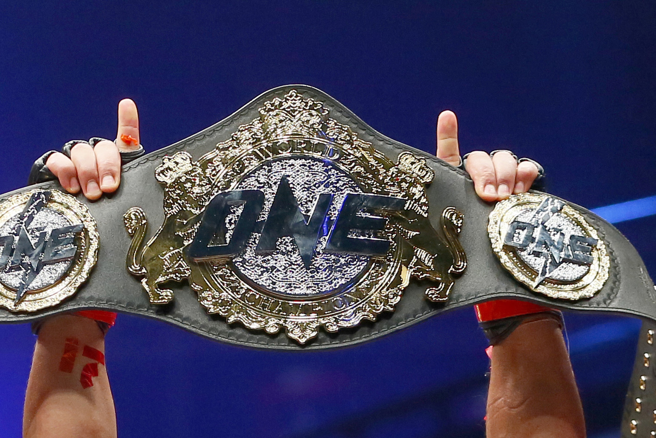 FILE - In this April 21, 2017, file photo, Philippines' Eduard Folayang raises his championship belt during an award ceremony after beating Malaysian-born Ev Ting in the lightweight Mixed Martial Arts title fight dubbed One FC (Fighting Championship), in Pasay city, south of Manila, Philippines. One Championship, the MMA organization out of Asia, is going global in 2019 and it's making the kind of moves that shows it plans to become a player in combat sports. (AP Photo/Bullit Marquez, File)