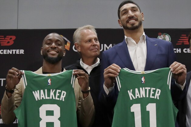 Newly acquired Boston Celtics guard Kemba Walker (8) and center Enes Kanter (11) pose with their team jerseys at the Celtics' basketball practice facility, Wednesday, July 17, 2019, in Boston. Looking on is team general manager Danny Ainge. (AP Photo/Elise Amendola)