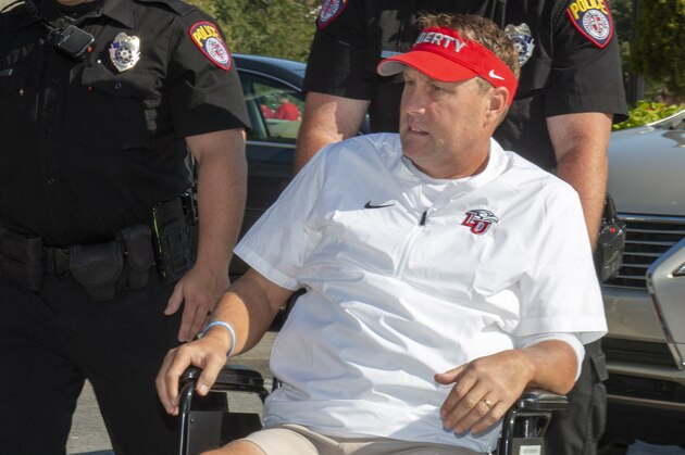 Liberty head football coach Hugh Freeze arrives to coach from a wheelchair in the coaches' box against Syracuse in an NCAA college football game in Lynchburg, Va., Saturday, Aug. 31, 2019. (AP Photo/Matt Bell)