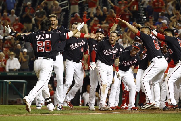 Washington Nationals greet Kurt Suzuki (28) as he approaches home plate after hitting a game-winning three-run home run in the team's baseball game against the New York Mets, Tuesday, Sept. 3, 2019, in Washington. Washington won 11-10. (AP Photo/Patrick Semansky)