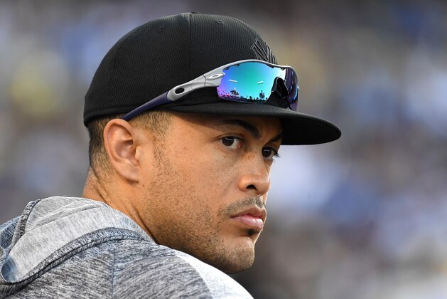 LOS ANGELES, CA - AUGUST 25: Giancarlo Stanton #27 of the New York Yankees looks on from the dugout during the game against the Los Angeles Dodgers at Dodger Stadium on August 25, 2019 in Los Angeles, California. Teams are wearing special color schemed uniforms with players choosing nicknames to display for Players' Weekend. (Photo by Jayne Kamin-Oncea/Getty Images)