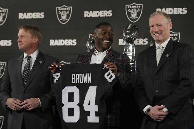 Oakland Raiders wide receiver Antonio Brown, center, holds his jersey beside coach Jon Gruden, left, and general manager Mike Mayock during an NFL football news conference Wednesday, March 13, 2019, in Alameda, Calif. (AP Photo/Ben Margot)