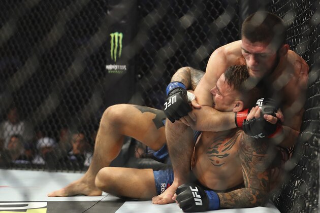 Russian UFC fighter Khabib Nurmagomedov, choke holds UFC fighter Dustin Poirier, of Lafayette, La., during Lightweight title mixed martial arts bout at UFC 242, in Yas Mall in Abu Dhabi, United Arab Emirates, Saturday , Sept.7 2019. (AP Photo/ Mahmoud Khaled)