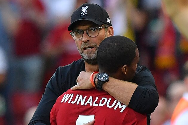 Liverpool's German manager Jurgen Klopp embraces Liverpool's Dutch midfielder Georginio Wijnaldum as he's substituted during the English Premier League football match between Liverpool and Arsenal at Anfield in Liverpool, north west England on August 24, 2019. (Photo by Ben STANSALL / AFP) / RESTRICTED TO EDITORIAL USE. No use with unauthorized audio, video, data, fixture lists, club/league logos or 'live' services. Online in-match use limited to 120 images. An additional 40 images may be used in extra time. No video emulation. Social media in-match use limited to 120 images. An additional 40 images may be used in extra time. No use in betting publications, games or single club/league/player publications. /         (Photo credit should read BEN STANSALL/AFP/Getty Images)