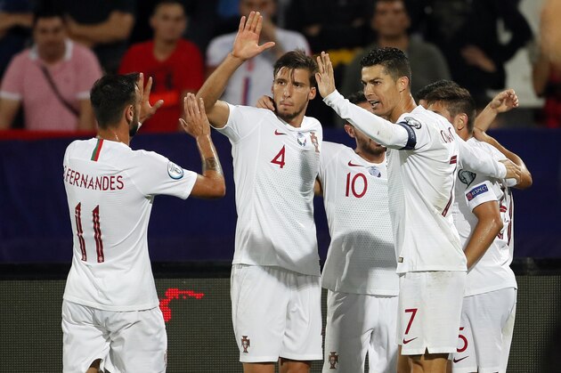 (FromL) Portugal's midfielder Bruno Fernandes, Portugal's defender Ruben Dias and Portugal's forward Cristiano Ronaldo celebrate a goal during the EURO 2020 football qualification match between Serbia and Portugal in Belgrade, Serbia, on September 7, 2019. (Photo by PEDJA MILOSAVLJEVIC / AFP)        (Photo credit should read PEDJA MILOSAVLJEVIC/AFP/Getty Images)