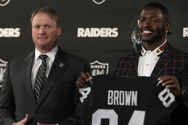 Oakland Raiders wide receiver Antonio Brown, right, holds his jersey beside coach Jon Gruden during an NFL football news conference, Wednesday, March 13, 2019, in Alameda, Calif. (AP Photo/Ben Margot)
