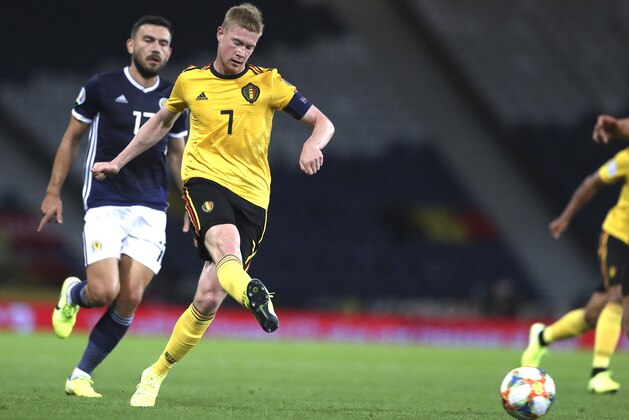 Belgium's Kevin De Bruyne, second left, kicks the ball as he is chased by Scotland's Robert Snodgrass during the Euro 2020 group I qualifying soccer match between Scotland and Belgium at Hampden Park stadium in Glasgow, Monday, Sept. 9, 2019. (AP Photo/Scott Heppell)