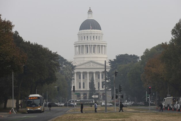The California state Capitol is viewed through the smoke from the Camp Fire, Tuesday, Nov. 13, 2018, in Sacramento, Calif. Smoke from the Camp Fire, which has been burning since last Thursday nearly 90 miles north of Sacramento, has blanketed much of Northern California. The has has destroyed thousands of homes and killed dozens of people. (AP Photo/Rich Pedroncelli)