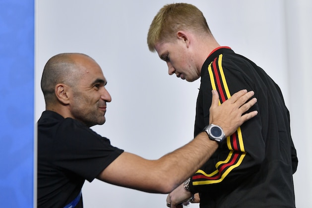 Belgium's Kevin De Bruyne leaves behind arriving Belgium coach Roberto Martinez during Belgium's official press conference on the eve of the semifinal match between France and Belgium at the 2018 soccer World Cup at the St. Petersburg Stadium in St. Petersburg, Russia, Monday, July 9, 2018. (AP Photo/Martin Meissner)