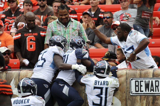Tennessee Titans cornerback Malcolm Butler (21) celebrates with a fan and teammates after returning an interception for a touchdown against the Cleveland Browns during the second half in an NFL football game, Sunday, Sept. 8, 2019, in Cleveland. (AP Photo/Ron Schwane)