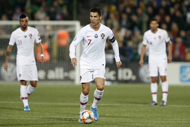 Portugal's Cristiano Ronaldo, center, controls the ball during the Euro 2020 group B qualifying soccer match between Lithuania and Portugal at LFF stadium in Vilnius, Lithuania, Tuesday, Sept. 10, 2019. (AP Photo/Mindaugas Kulbis)