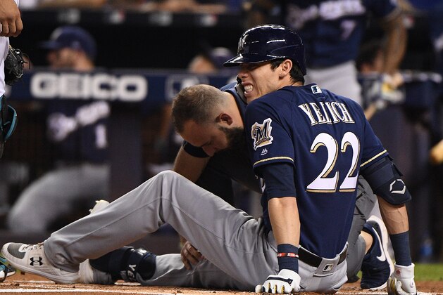 MIAMI, FLORIDA - SEPTEMBER 10: Christian Yelich #22 of the Milwaukee Brewers is checked out by the medical staff after an injury from ball deflection in the first inning against the Miami Marlins at Marlins Park on September 10, 2019 in Miami, Florida. (Photo by Mark Brown/Getty Images)