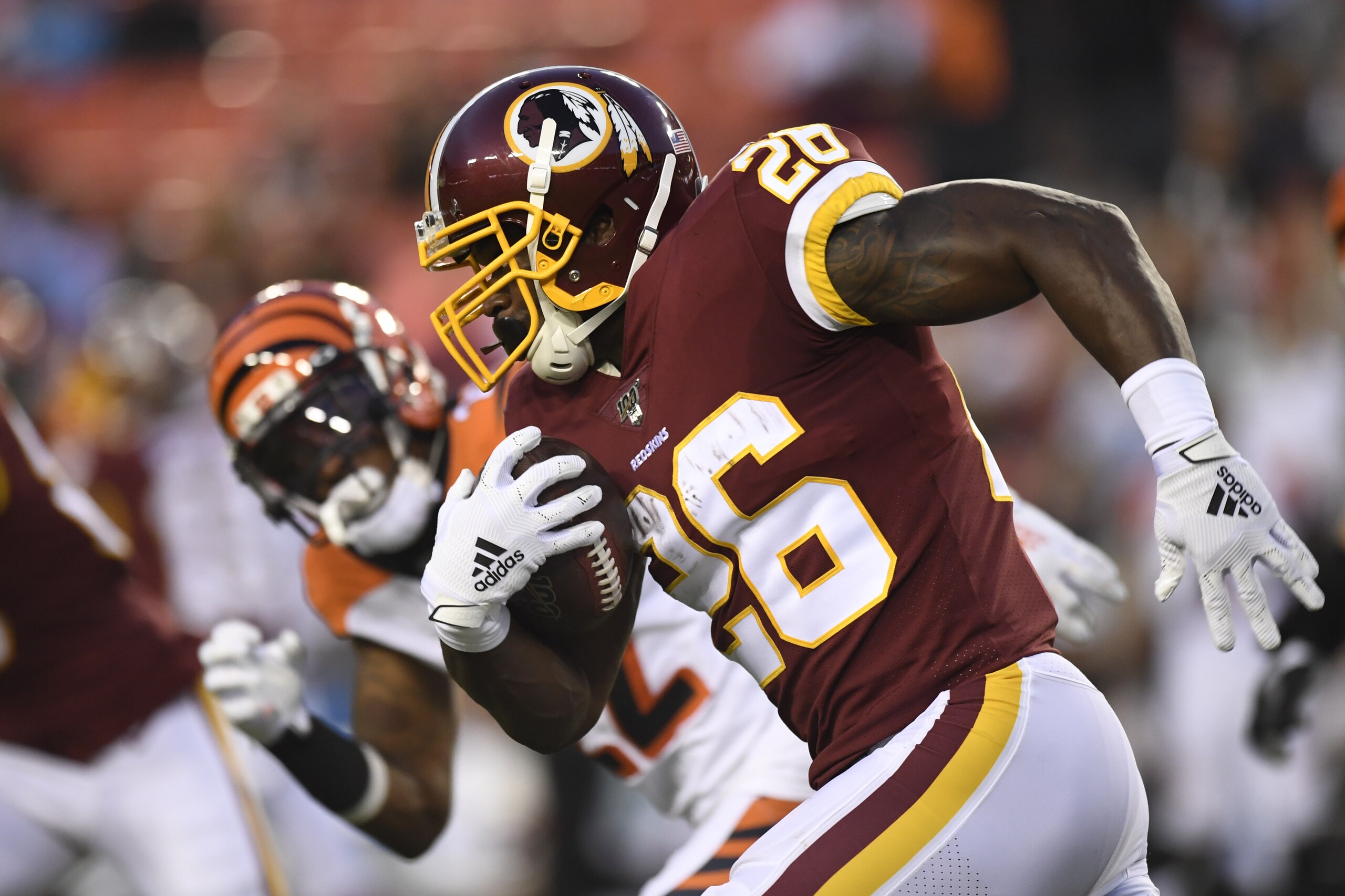 Washington Redskins running back Adrian Peterson (26) carries the ball past the Cincinnati Bengals during the first quarter of an NFL preseason football game in Landover, Md., Thursday, Aug. 15, 2019. (AP Photo/Susan Walsh)