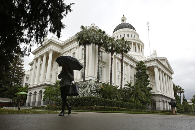 A woman uses an umbrella as it rains at the Capitol, Thursday, May 16, 2019, in Sacramento, Calif. A late-spring storm with a winter-like potency moved through California, adding to the Sierra Nevada snowpack and rainfall accumulations that were already well above normal. (AP Photo/Rich Pedroncelli)