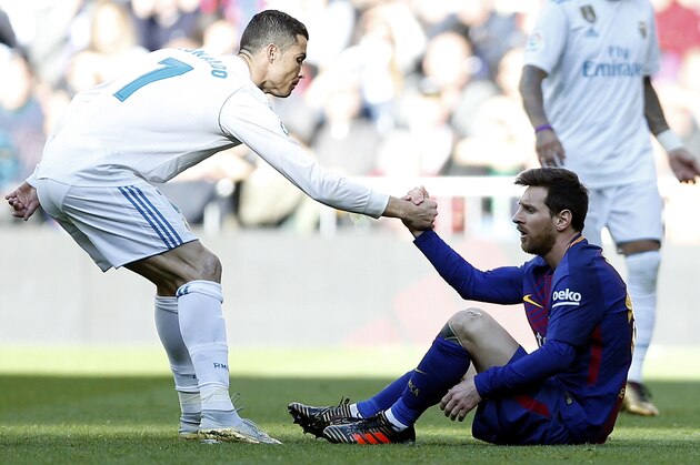Real Madrid's Cristiano Ronaldo, left, helps Barcelona's Lionel Messi get back on his feet during the Spanish La Liga soccer match between Real Madrid and Barcelona at the Santiago Bernabeu stadium in Madrid, Spain, Saturday, Dec. 23, 2017. (AP Photo/Francisco Seco)