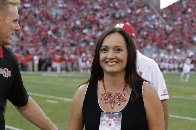 Wendy Anderson, center, wife of Arkansas State head coach Blake Anderson, left, smiles after chatting with Nebraska head coach Mike Riley, rear, before an NCAA college football game in Lincoln, Neb., Saturday, Sept. 2, 2017. (AP Photo/Nati Harnik)