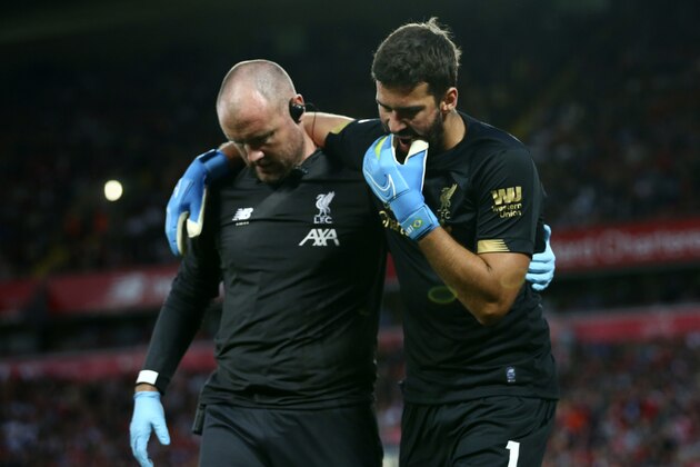 Liverpool's goalkeeper Alisson Becker, right, reacts as he leaves the pitch after an injury during the English Premier League soccer match between Liverpool and Norwich City at Anfield in Liverpool, England, Friday, Aug. 9, 2019. (AP Photo/Dave Thompson)