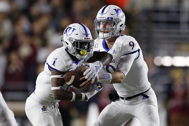 Kansas quarterback Carter Stanley (9) hands off to running back Pooka Williams Jr. (1) during the first half of an NCAA college football game in Boston, Friday, Sept. 13, 2019. (AP Photo/Michael Dwyer)