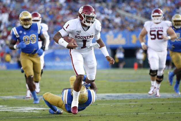 LOS ANGELES, CALIFORNIA - SEPTEMBER 14:  Jalen Hurts #1 of the Oklahoma Sooners runs over Stephan Blaylock #4 of the UCLA Bruins during the first half of a game on at the Rose Bowl on September 14, 2019 in Los Angeles, California. (Photo by Sean M. Haffey/Getty Images)