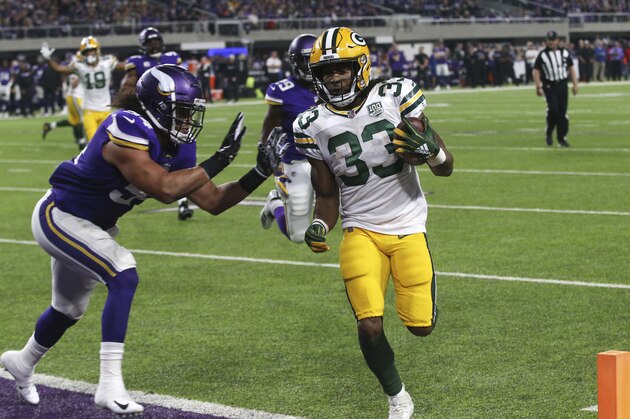 Green Bay Packers running back Aaron Jones (33) scores on a 6-yard touchdown run ahead of Minnesota Vikings middle linebacker Eric Kendricks, left, during the first half of an NFL football game Sunday, Nov. 25, 2018, in Minneapolis. (AP Photo/Jim Mone)
