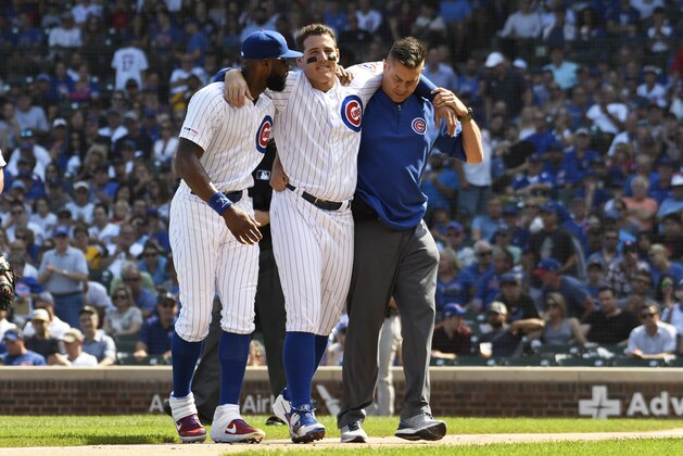 CHICAGO, ILLINOIS - SEPTEMBER 15: Anthony Rizzo of the Chicago Cubs is helped off the field by Jason Heyward (L) and trainer PJ Mainville after being injured against the Pittsburgh Pirates during the third inning at Wrigley Field on September 15, 2019 in Chicago, Illinois. (Photo by David Banks/Getty Images)
