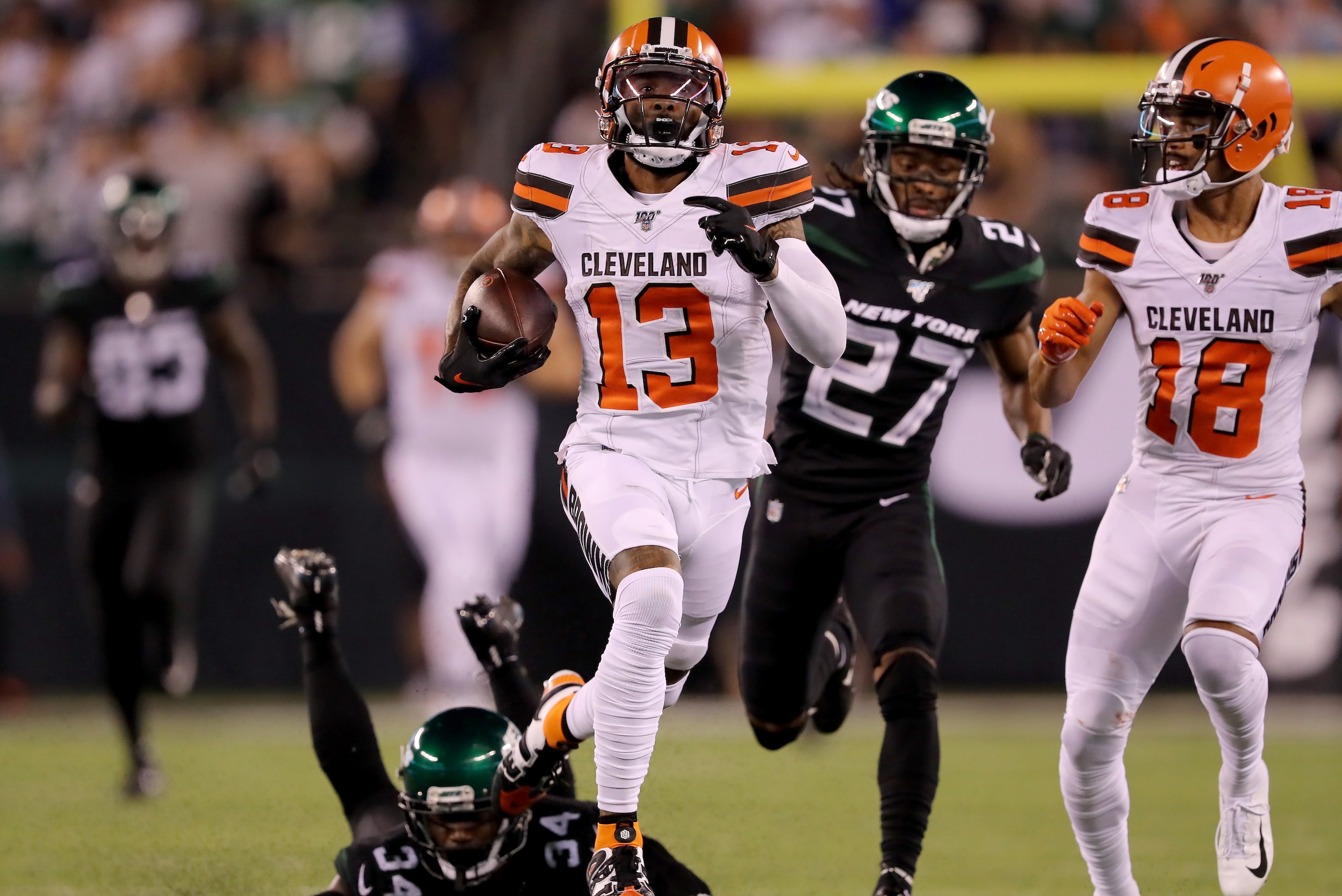 EAST RUTHERFORD, NEW JERSEY - SEPTEMBER 16:  Odell Beckham Jr. #13 of the Cleveland Browns breaks free from Brian Poole #34 and Darryl Roberts #27 of the New York Jets to run the ball 89 yards in for the touchdown in the third quarter at MetLife Stadium on September 16, 2019 in East Rutherford, New Jersey. (Photo by Elsa/Getty Images)