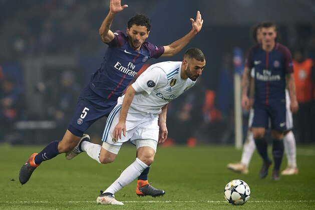 PARIS, FRANCE - MARCH 06:  Marquinhos of Paris Saint-Germain competes for the ball with Karim Benzema (R) of Real Madrid during the UEFA Champions League Round of 16 Second Leg match between Paris Saint-Germain and Real Madrid at Parc des Princes on March 6, 2018 in Paris, France.  (Photo by Manuel Queimadelos Alonso/Getty Images)