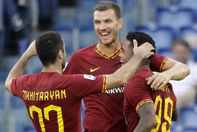 Roma's Justin Kluivert is celebrated by his teammates Roma's Edin Dzeko, center, and Roma's Henrikh Mkhitaryan, left, after scoring during a Serie A soccer match between Roma and Sassuolo, in Rome, Sunday, Sept. 15, 2019. (AP Photo/Gregorio Borgia)