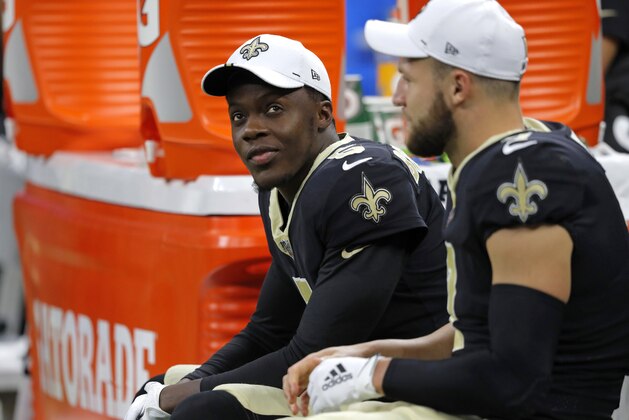 New Orleans Saints quarterbacks Teddy Bridgewater, left, and Taysom Hill sit on the bench in the first half of an NFL preseason football game in New Orleans, Thursday, Aug. 29, 2019. (AP Photo/Bill Feig)
