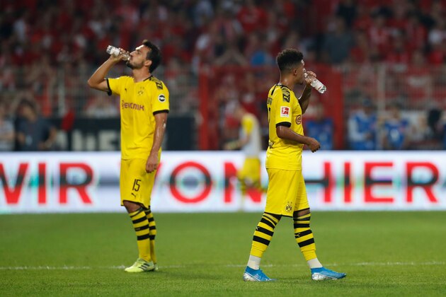 Dortmund's German defender Mats Hummels (L) and Dortmund's English midfielder Jadon Sancho drink during a drinks break because of the heat during the German first division Bundesliga football match FC Union Berlin versus Borussia Dortmund in Berlin on August 31, 2019. (Photo by Odd ANDERSEN / AFP) / RESTRICTIONS: DFL REGULATIONS PROHIBIT ANY USE OF PHOTOGRAPHS AS IMAGE SEQUENCES AND/OR QUASI-VIDEO        (Photo credit should read ODD ANDERSEN/AFP/Getty Images)