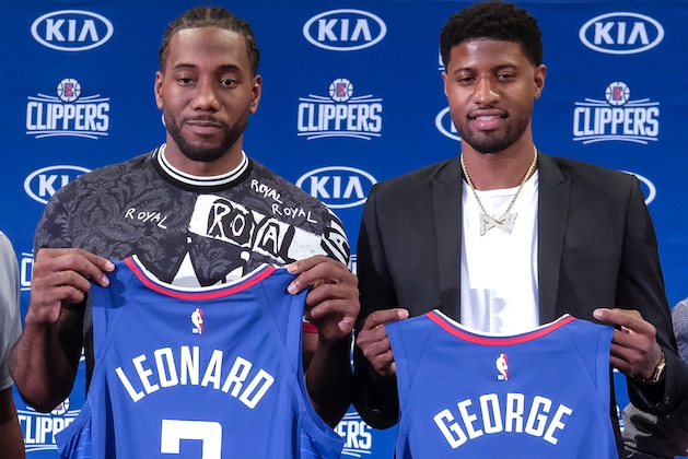Kawhi Leonard, left, and Paul George pose with their new team jerseys during a press conference in Los Angeles, Wednesday, July 24, 2019. Nearly three weeks after the native Southern California superstars shook up the NBA by teaming up with the Los Angeles Clippers, the dynamic duo makes its first public appearance. (AP Photo/Ringo H.W. Chiu)
