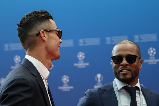 Portuguese forward Cristiano Ronaldo (L) greets retired French defender Patrice Evra as he arrives prior to the UEFA Champions League football group stage draw ceremony in Monaco on August 29, 2019. (Photo by Valery HACHE / AFP)        (Photo credit should read VALERY HACHE/AFP/Getty Images)